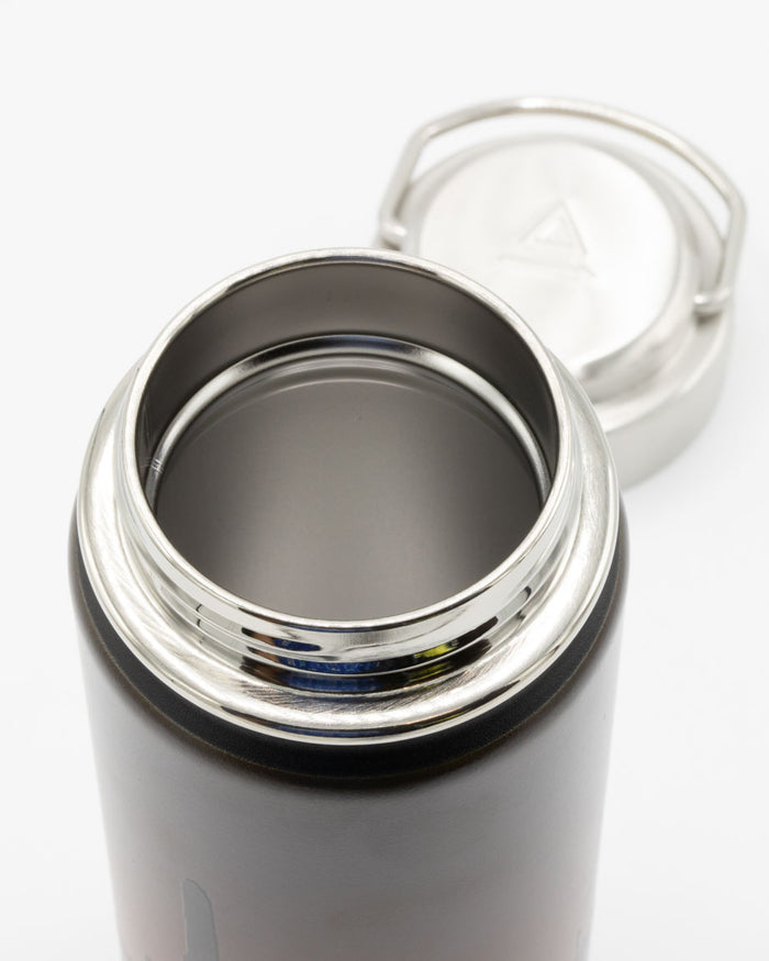 A Cognitive Surplus Desert Moon 18 oz Steel Bottle with a lid.