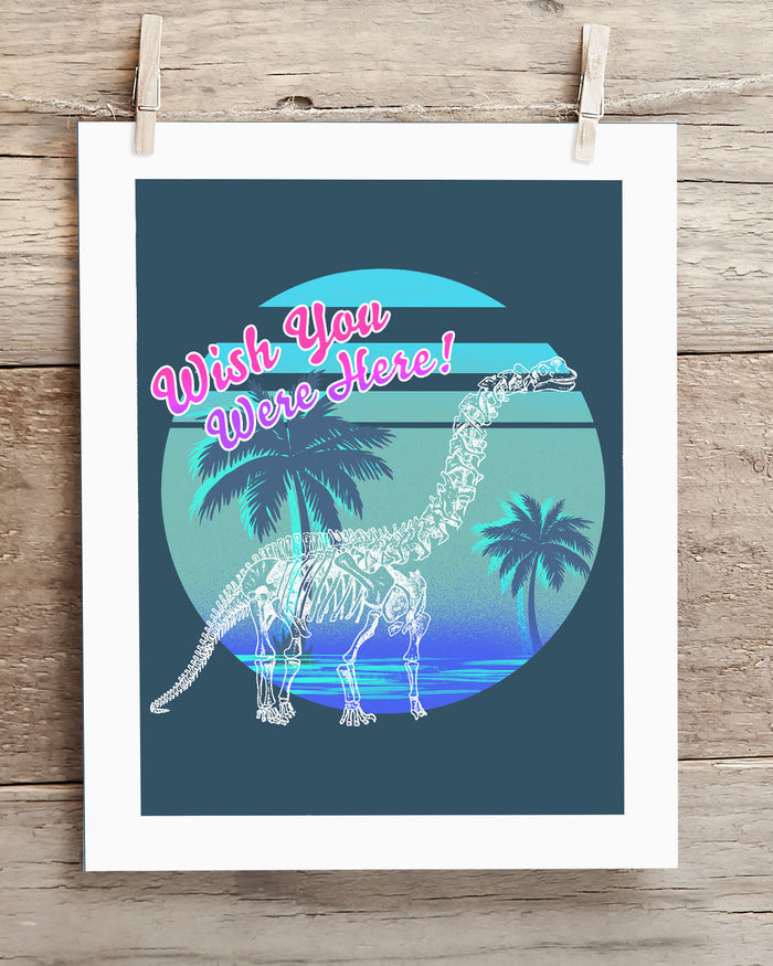 A Dino: Wish You Were Here! Museum Print poster with a dinosaur and palm trees hanging on it, made by Cognitive Surplus.