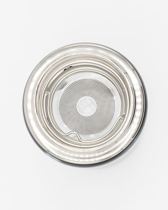 An Infuser Basket for Stainless Steel Bottles with a lid on a white surface by Cognitive Surplus.