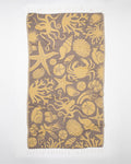 A yellow and brown Tide Pool Turkish Towel with an octopus on it.