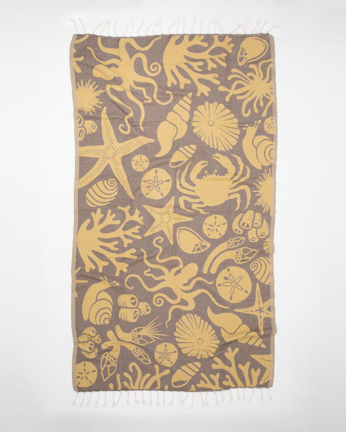 A yellow and brown Tide Pool Turkish Towel with an octopus on it.