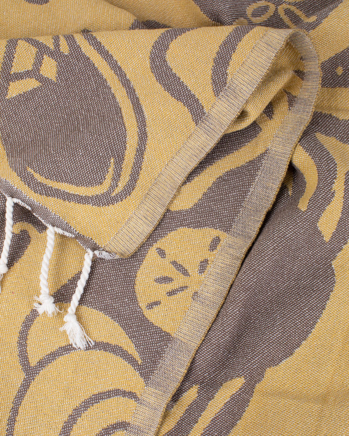 A Tide Pool Turkish Towel with tassels on it.