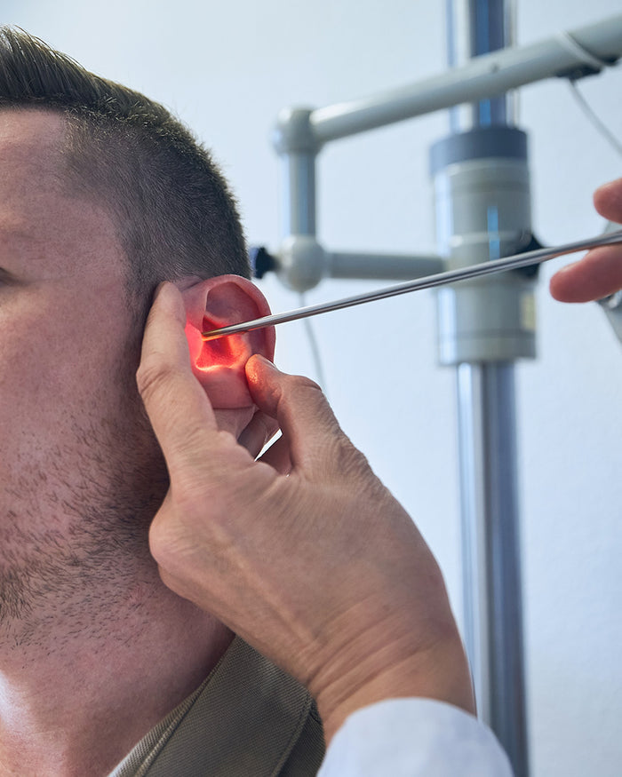 A man is having his ear examined by a doctor with the Up Close and Personal Mystery Sticker Pack from Cognitive Surplus.